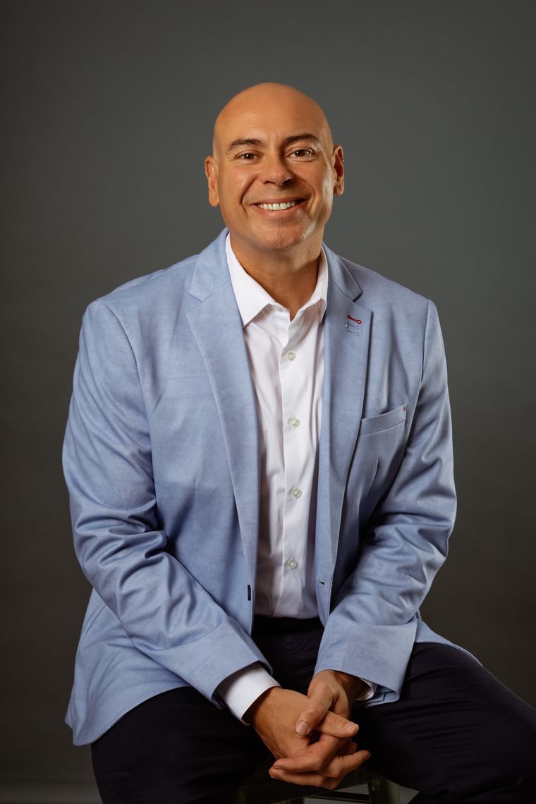 John Sorrell, founder of Crux to Clarity, smiling in a light blue blazer.